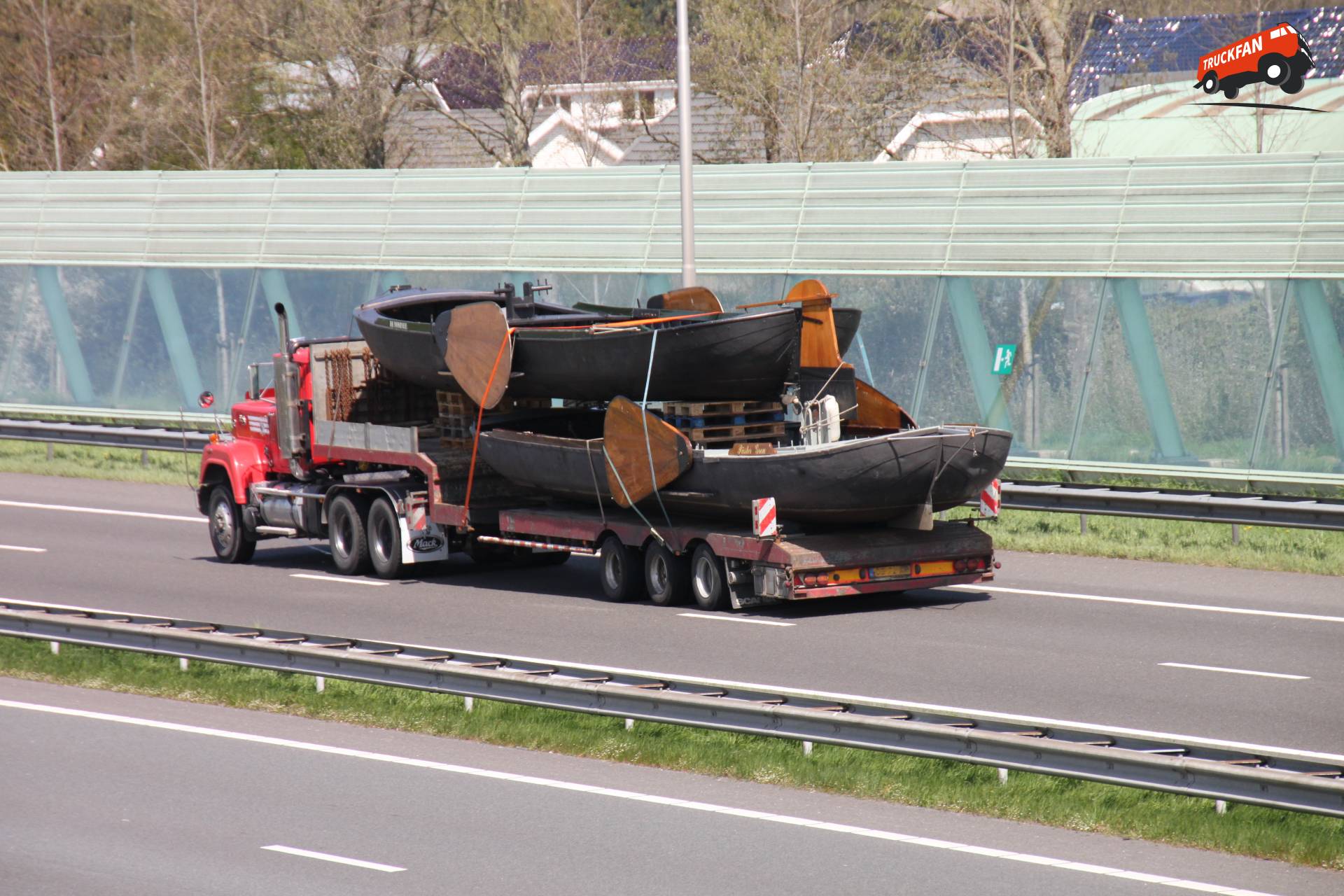 Zwalve machine achter een Mack vrachtwagen