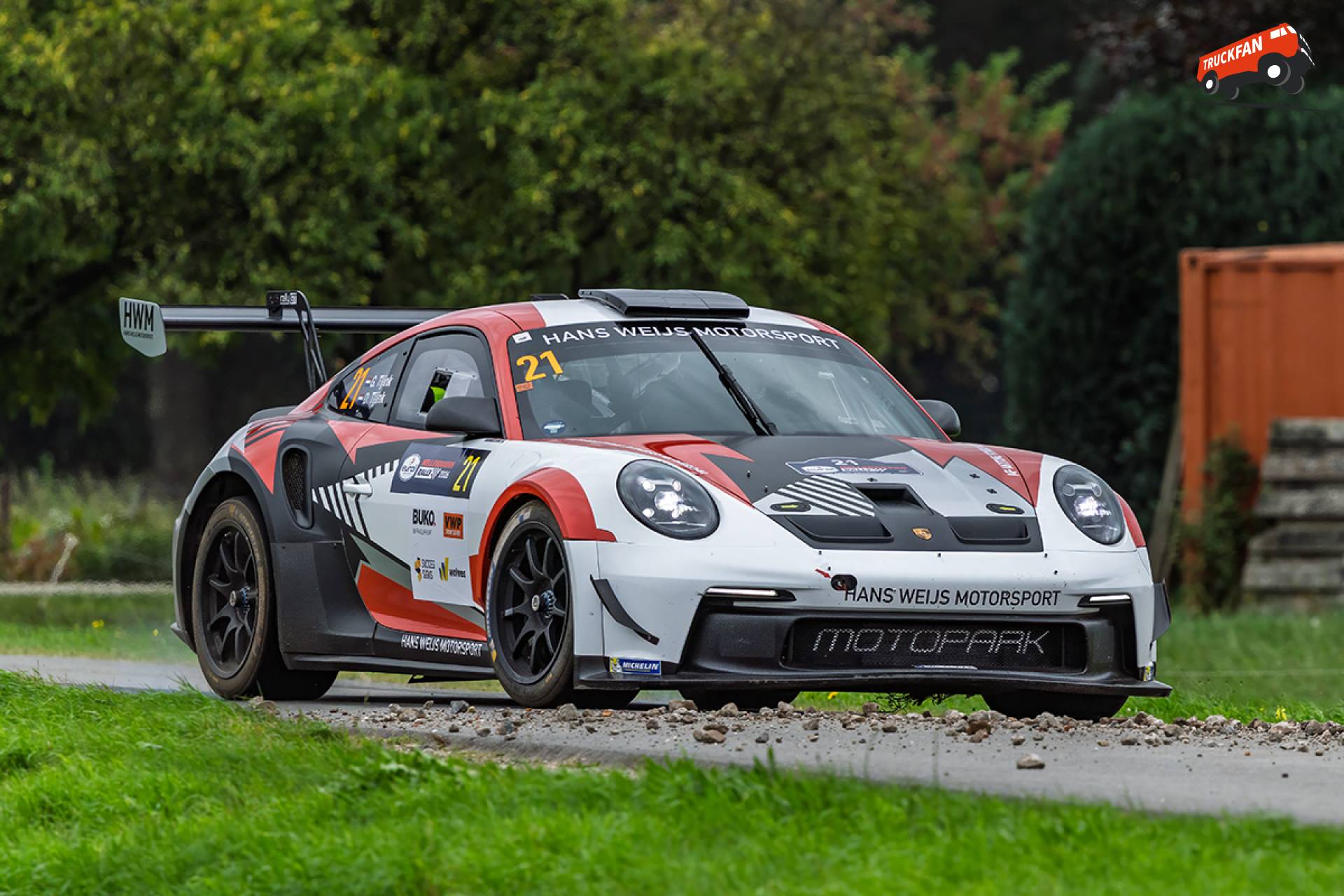 Porsche over onverharde weg naar zandpad