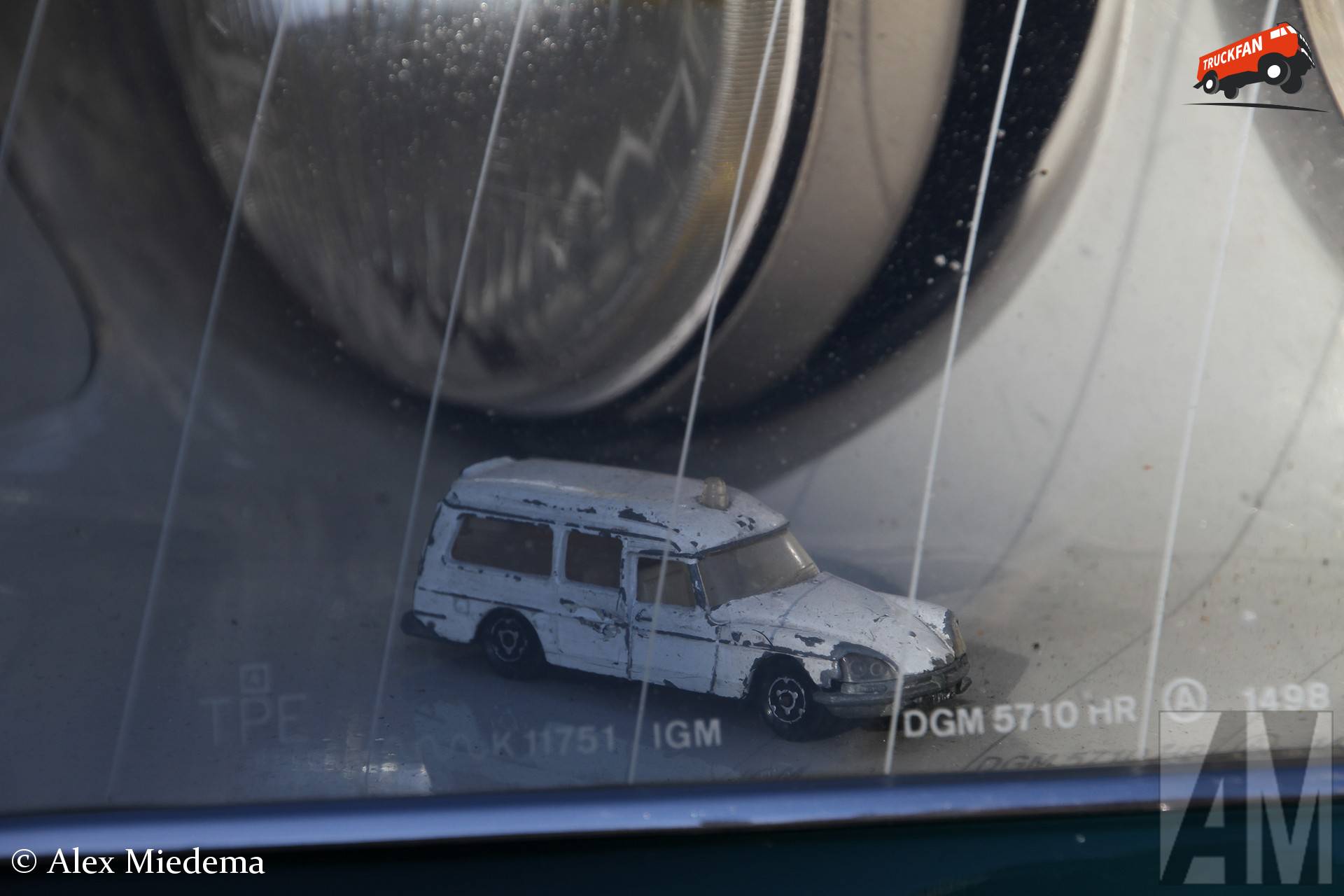 Miniatuur van een Citroën DS ambulance in de koplamp van een 1:1 Citroën DS.