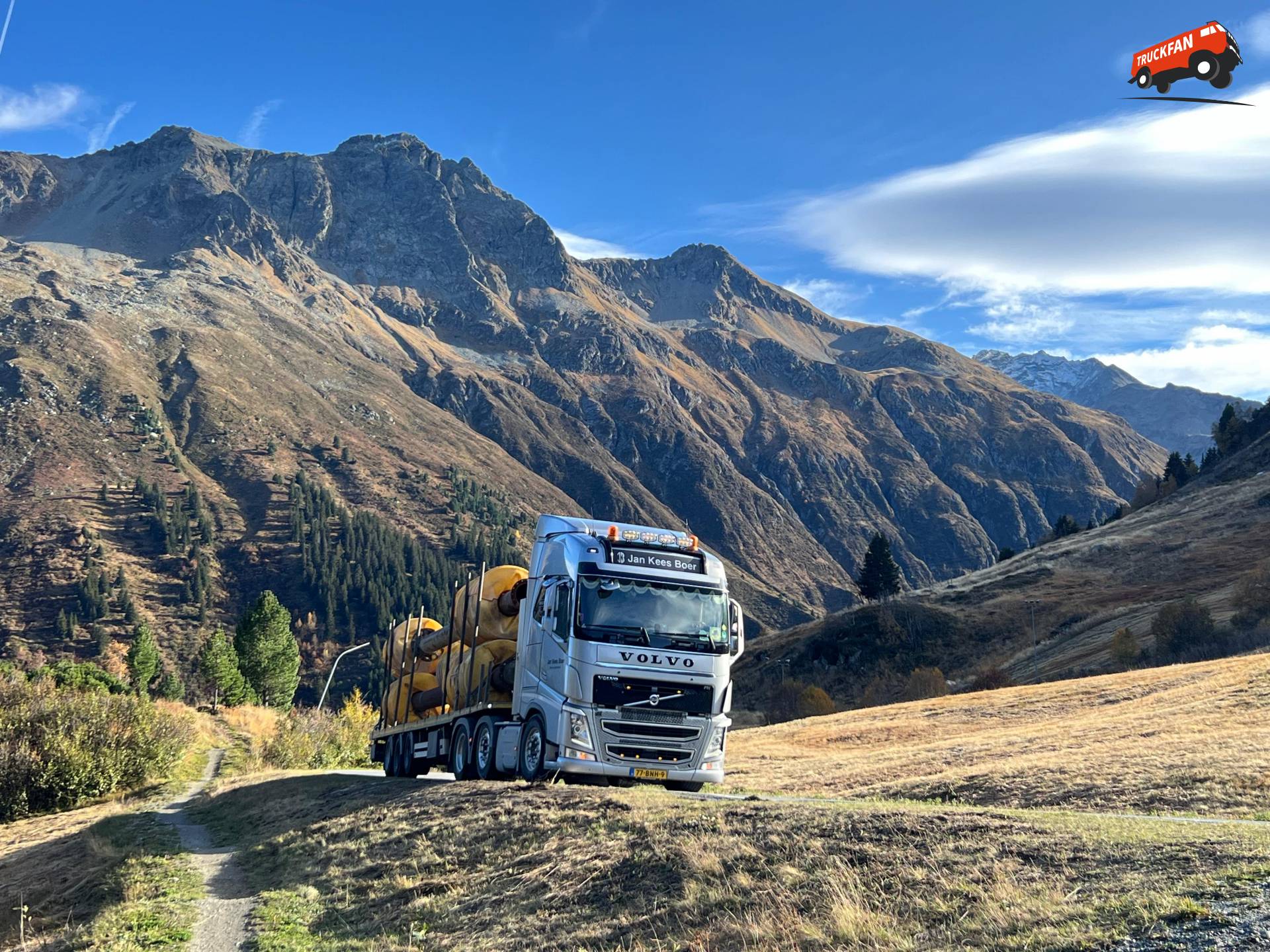 Grijze Volvo met leiding voor zandzuiger door Alpen