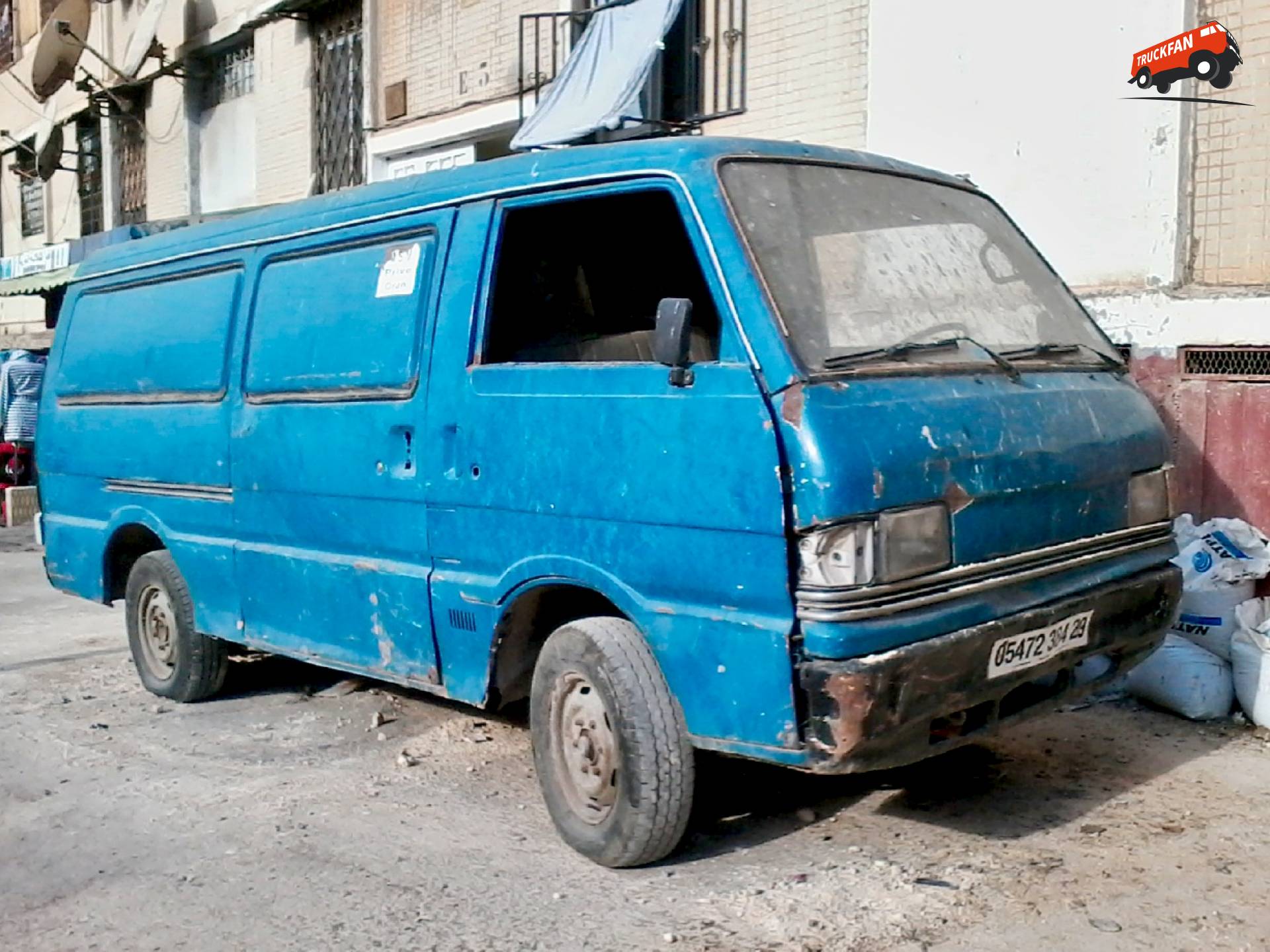 Mazda E2200 bus geparkeerd in stedelijk landschap van Algerije